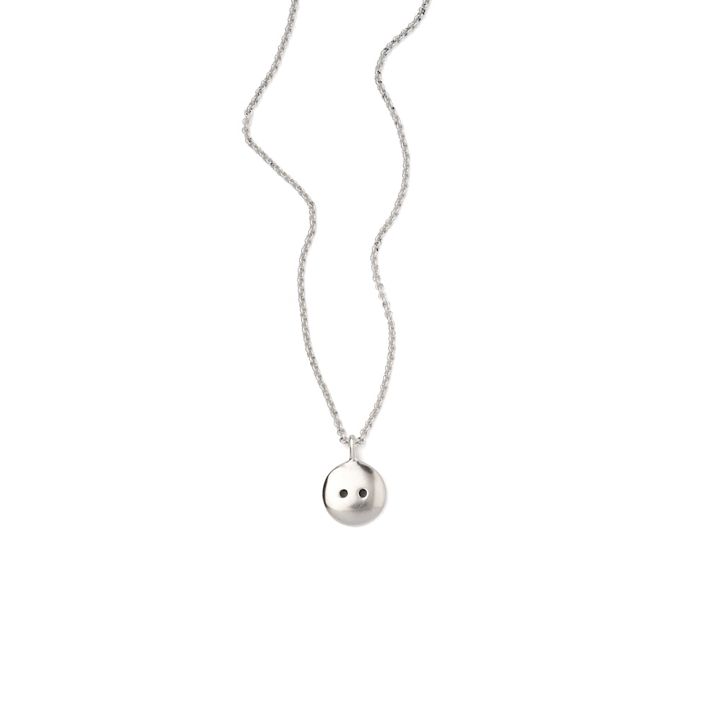 A close up image of the Button Pendant on a ball chain