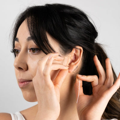 An image of a model putting the Curved Danglebacks in her ear