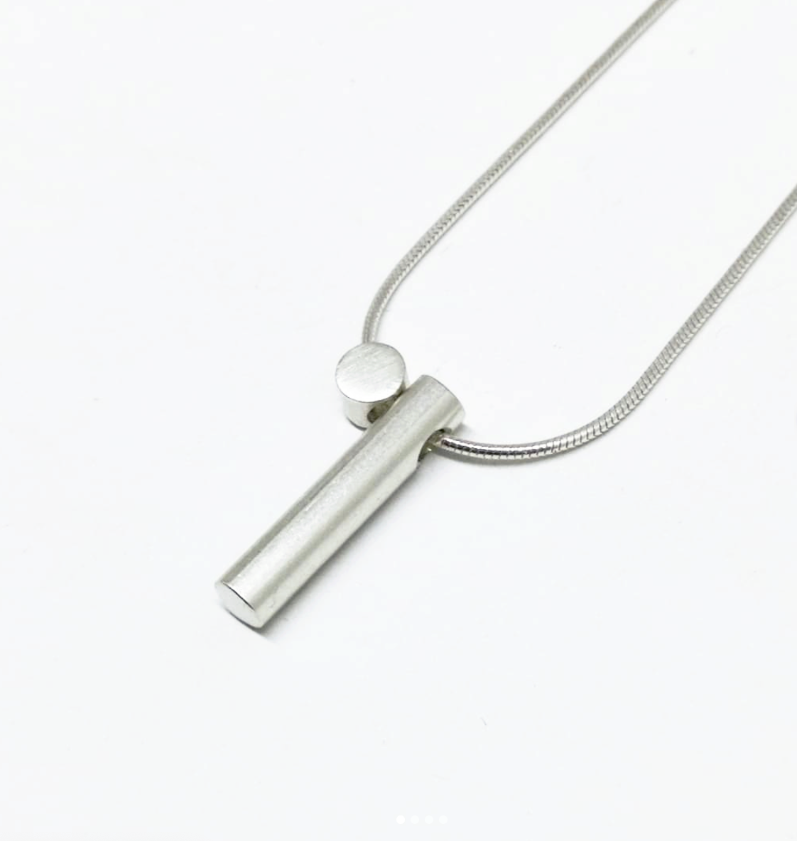 A close up image of the Cylinder Pendant Set on a snake chain