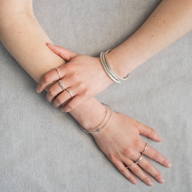 An image of Everyday Bands and Tiny Rings in silver worn on the body