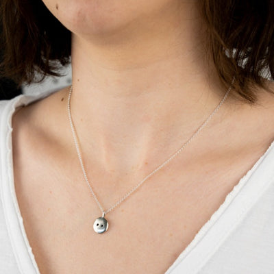 An image of the Button Pendant worn on the body