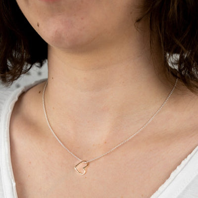 A close up image of the silver Openhearted Pendant worn on the body