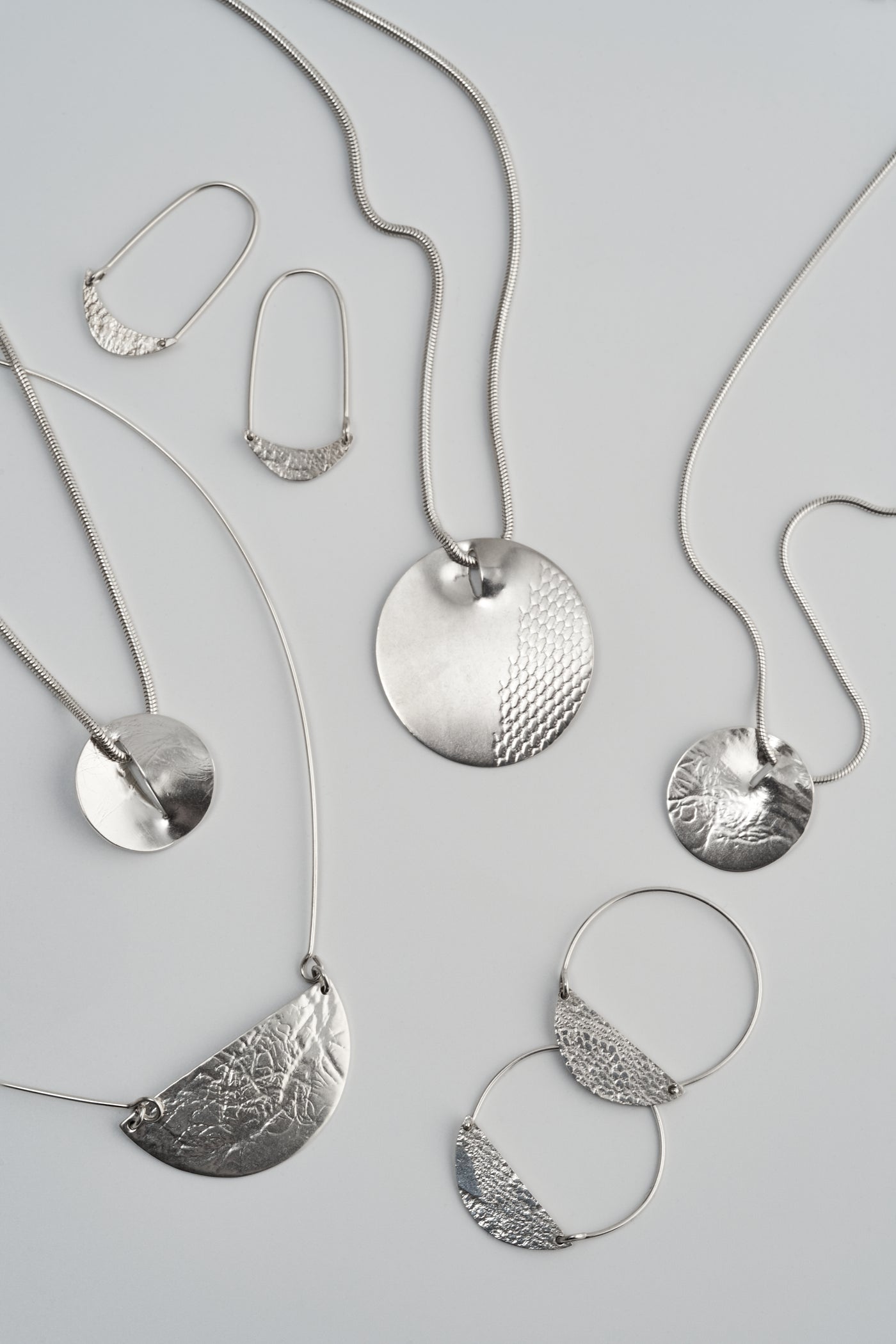 An image of the Lace and Lichen collection, including the Crescent Moon Earrings