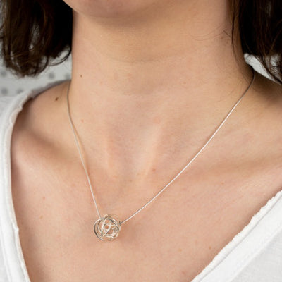 A close up image of the Scribble Bead Pendant worn on the body
