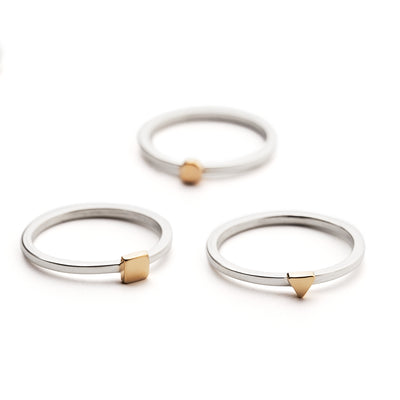An image of three Tiny rings in gold and silver displayed on a surface