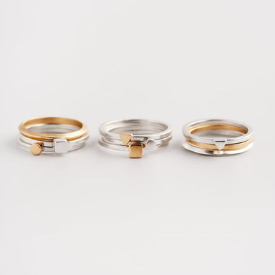 An image of three stacks of Tiny and Everyday Rings in silver and gold